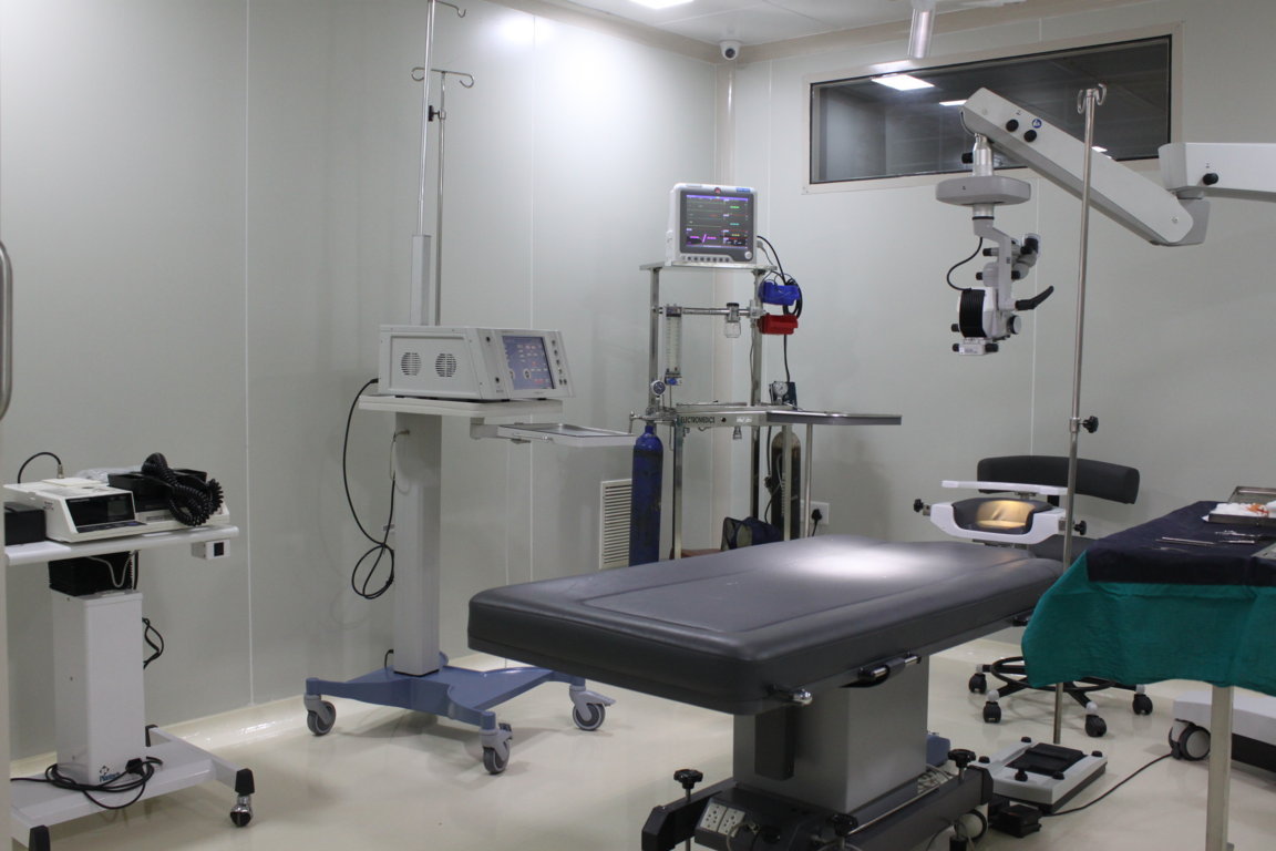 Insight Institute operating bay configured for ophthalmic surgery, with anaesthesia trolley, patient vitals monitor and overhead Zeiss surgical optics